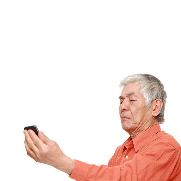 Elderly man holding phone at a distance